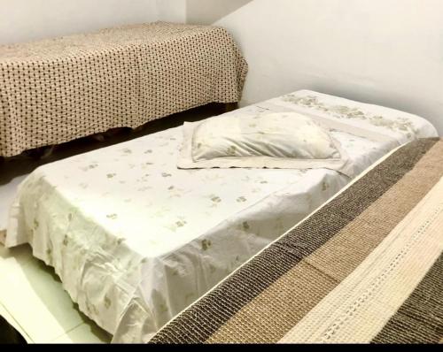 Una cama sin hacer con una almohada en una habitación en Green House en Corumbau