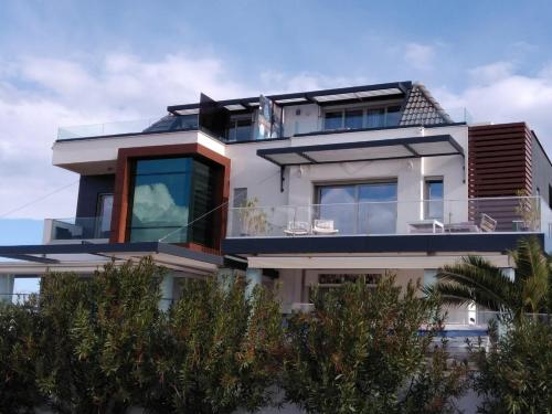 a white building with trees in front of it at Mavi Panorama Villa in Cesme