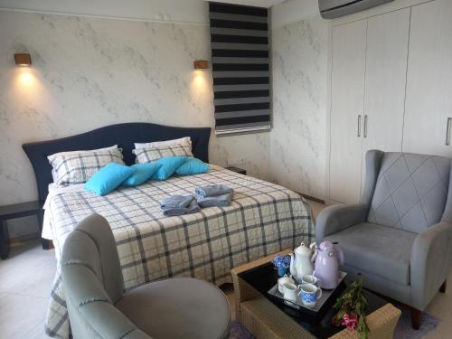 a bedroom with a bed and two chairs and a table at Mavi Panorama Villa in Cesme