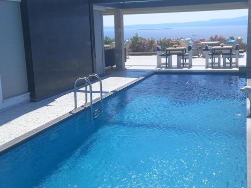 a swimming pool with blue water in a house at Mavi Panorama Villa in Cesme