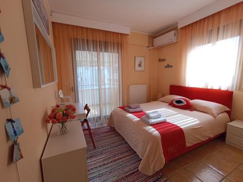 a bedroom with a bed and a vase of flowers at the Cruiseflat seafront apartment & free parking in Thessaloniki