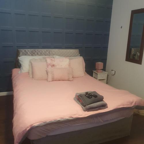 Schlafzimmer mit einem Bett mit rosa Bettwäsche und Kissen in der Unterkunft Sunningdale in Conisbrough