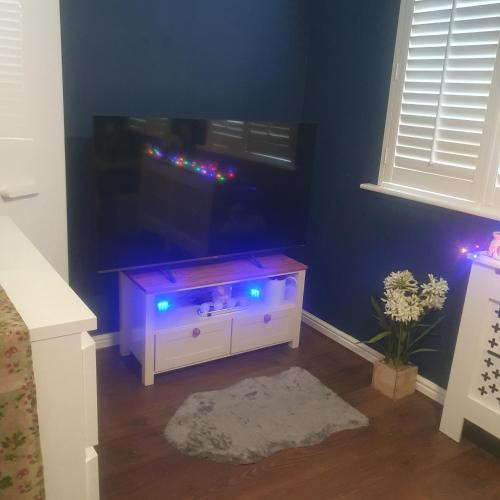 a living room with a tv and a white cabinet at Sunningdale in Conisbrough