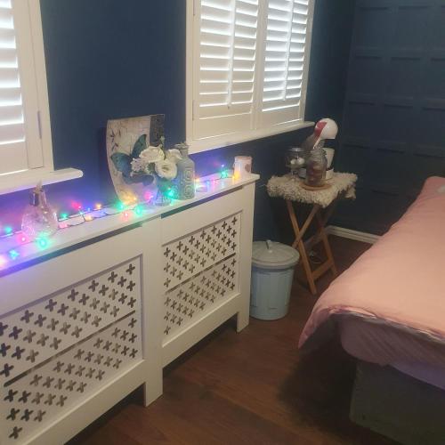 a bedroom with a white dresser with lights on it at Sunningdale in Conisbrough