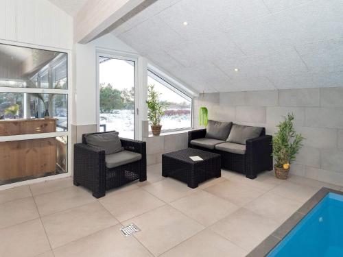 een woonkamer met een bank en stoelen en een zwembad bij 14 person holiday home in L gst r in Trend