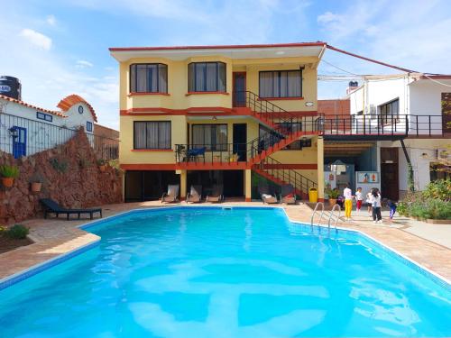 a house with a swimming pool in front of a building at Hotel Mitru in Tupiza