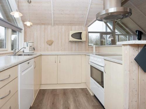 a kitchen with white cabinets and white appliances at 9 person holiday home in Hemmet in Falen