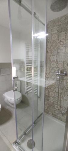 ein Bad mit einem WC und einer Glasdusche in der Unterkunft Casa Ferny in Mottola