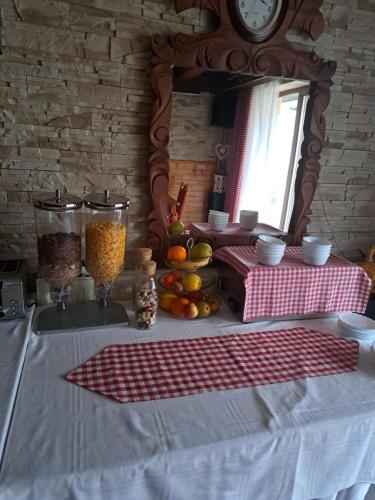 a kitchen with a table with a clock on a mirror at Penzion Havran in Ždiar
