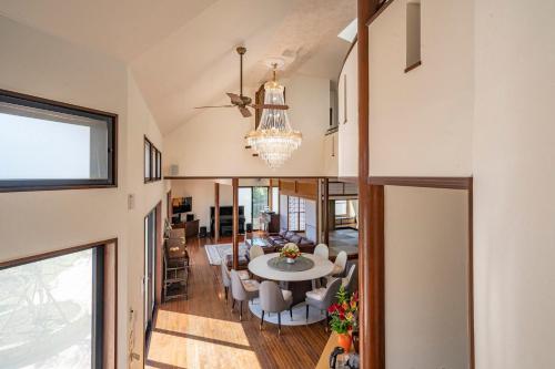 a dining room and living room with a chandelier at Grand Maison W 館山美食倶楽部 in Tateyama