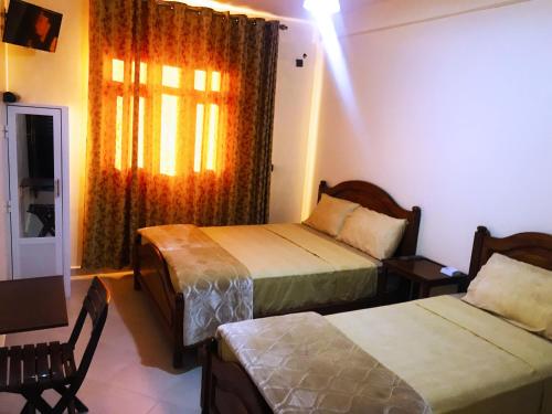 una camera d'albergo con due letti e una finestra di HOTEL TIZNIT AFOULKI a Tiznit