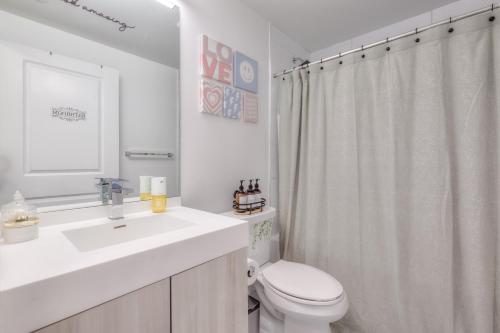 Baño blanco con aseo y lavamanos en Stunning Suite in Heart of Downtown Toronto J4, en Toronto