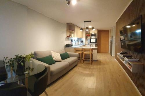 a living room with a couch and a kitchen at Departamento céntrico nuevo in Valdivia