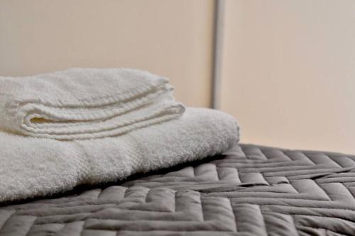 una pila de toallas sentadas encima de una cama en Amplio piso, con cochera 2 dormitorios 2 baños La Rural, Shopping Mall Distrito Arcos en Buenos Aires