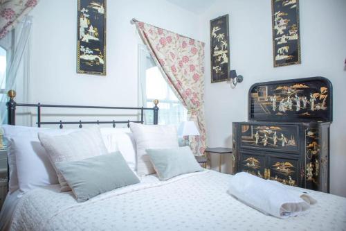 um quarto com uma cama branca e almofadas brancas em Spacious and Cosy House for 6 em Rochester