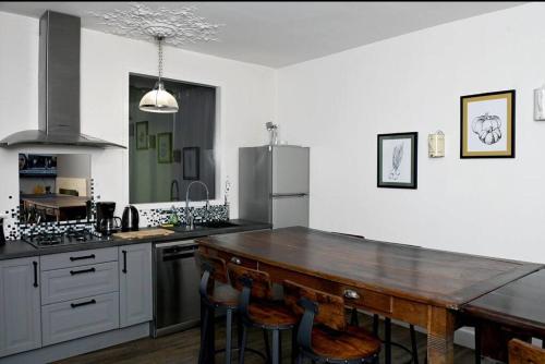 Il comprend une cuisine avec une table et des chaises en bois. dans l'établissement Le Majestic, à Verdun-sur-Meuse