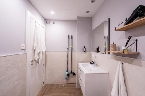 a white bathroom with a sink and a toilet at Apartamentos Jardines de la Sitarilla in Granada