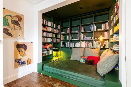 a room with a couch in a library with bookshelves at Hackney - Victoria Park Generous 2 Bed Terrace in London