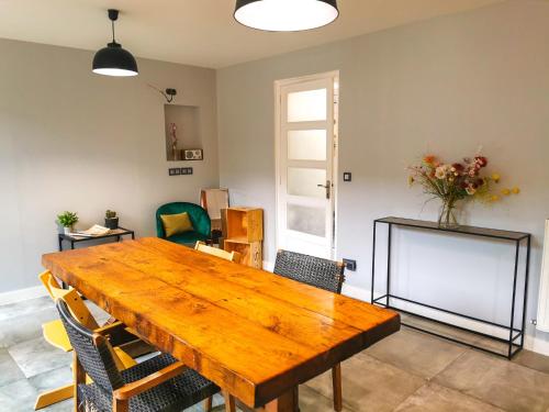 une salle à manger avec une table et des chaises en bois dans l'établissement Magnum 80 Terrasse & Climatisation - 6 personnes - BnB Epernay, à Épernay
