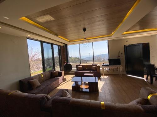 a living room with couches and a flat screen tv at Dolunay jarash in Jerash