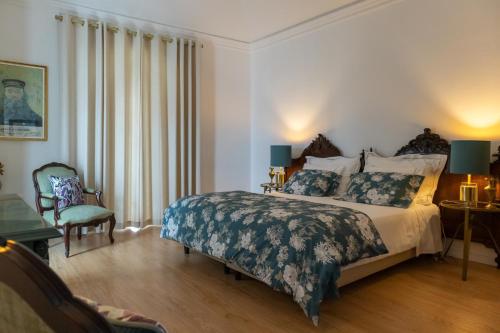 a bedroom with a large bed and a chair at Casa Brazao Mira in Casa Branca