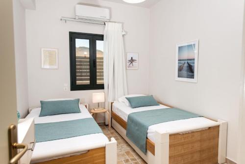a bedroom with two beds and a window at Gifel - Luxury apartment in Kalamaki Heraklion