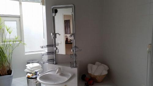 a white bathroom with a sink and a mirror at LebensART in Hautzenbichl