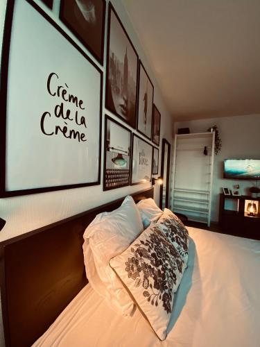 - une chambre dotée d'un lit avec un grand écran sur le mur dans l'établissement Travel Homes - Le Bright'N Cosy en pleine ville, à Mulhouse