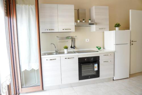 a white kitchen with a sink and a refrigerator at Il Posto per Te in Turi