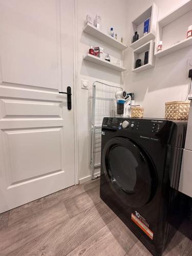 - un lave-linge dans une chambre avec porte dans l'établissement Super maison f2… avec jardin, à Bondy