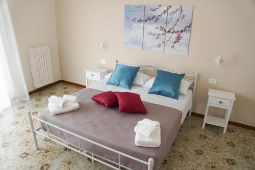 a bedroom with a bed with blue and red pillows at Il Posto per Te in Turi