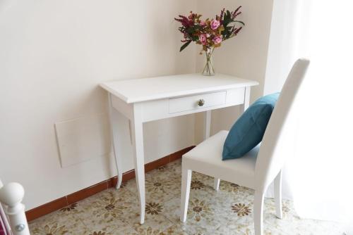 a white desk with a vase of flowers and a chair at Il Posto per Te in Turi