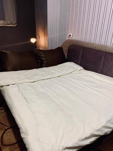 un letto con lenzuola bianche in una camera da letto di Iva Apartment a Rivne