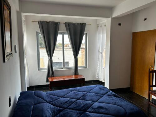 ラ・キアカにあるVirginia hotelのベッドルーム(青いベッド1台、窓付)