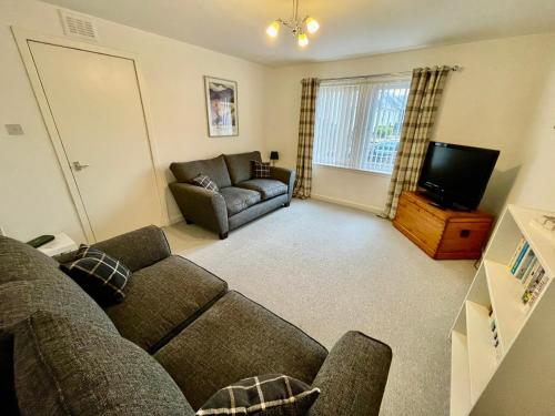 カレンにあるSpacious 2 Bedroom Home in Picturesque Cullenのソファとテレビのあるリビングルーム