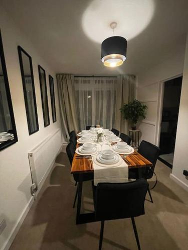 a dining room with a table with chairs and a tableablish at Elegant Cosy Home in Wembley 8 Max + Driveway in London