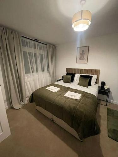 a bedroom with a bed with two towels on it at Elegant Cosy Home in Wembley 8 Max + Driveway in London
