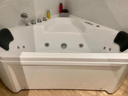 La salle de bains est pourvue d'une grande baignoire blanche. dans l'établissement Cottage normand, à La Croisille