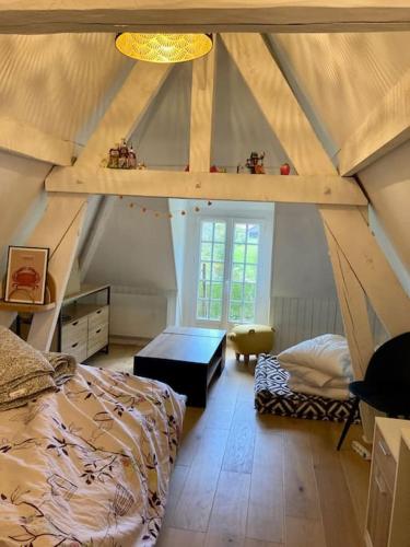 Cette chambre mansardée comprend un lit et un bureau. dans l'établissement Cottage normand, à La Croisille
