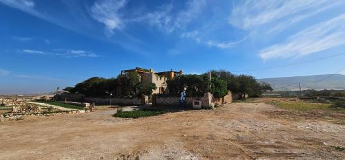 una strada sterrata di fronte a una casa su una collina di Golden Baibah a Zaouia Akermoud