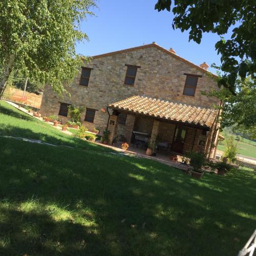 a large stone house with a large yard at Azienda Agrituristica I Tre Casali in Magione