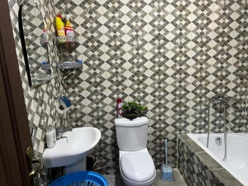 a bathroom with a toilet and a sink at Luxury Spacious Apartment in Kumasi