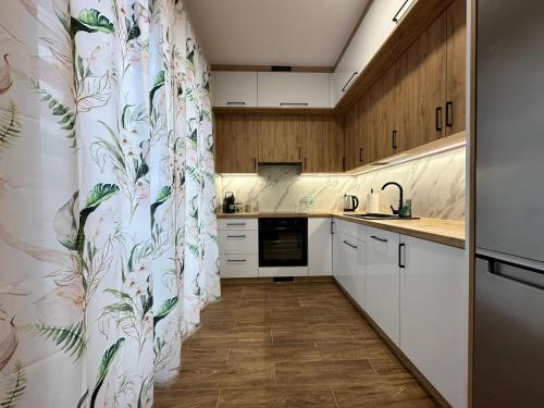 a kitchen with white cabinets and a floral wallpaper at Premium Apartment - Evergreen - SELF CHECK-IN - Parking in Rzeszów