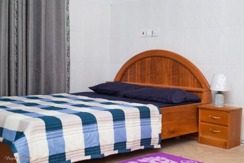 1 dormitorio con 1 cama con manta azul y blanca en Luxury Spacious Apartment, en Kumasi