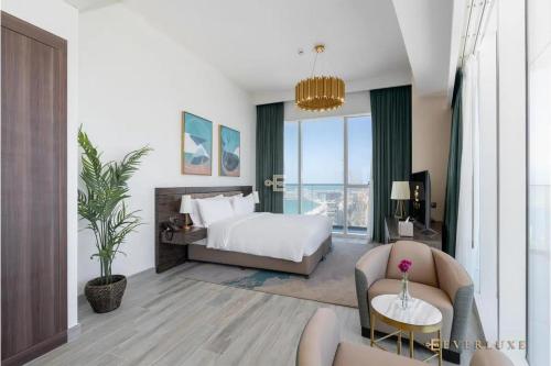 Everluxe Palm Views 3 Bedroom في دبي: غرفة فندقية بسرير ونافذة كبيرة