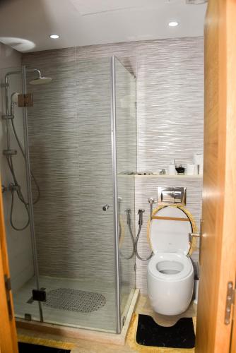 a bathroom with a toilet and a glass shower at Luxurious Apt with Pool&Sea View in Pont Blondin
