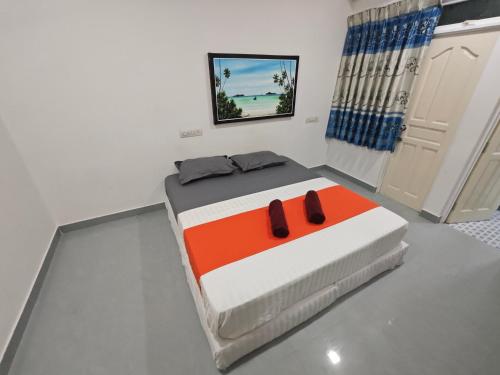 Un dormitorio con una cama con zapatillas. en Miyaru Lodge Divers en Mandhoo