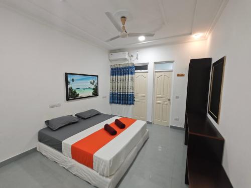 1 dormitorio con 1 cama con 2 zapatillas en Miyaru Lodge Divers en Mandhoo