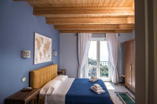 a blue bedroom with a bed and a large window at B&B Casa Martino SEA VIEW in Vietri