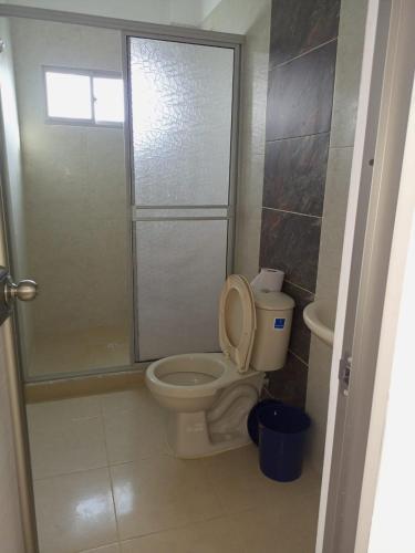 een badkamer met toilet met deksel bij Apartamentos Mi Reserva OK - Miraluna in Coveñas